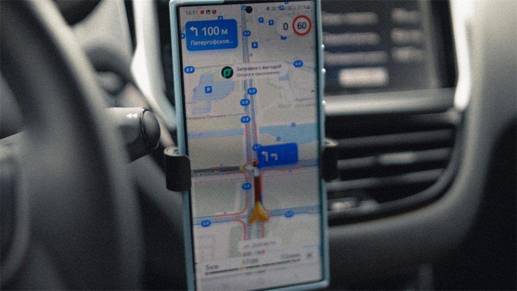 Celular preso ao painel do carro exibindo um aplicativo