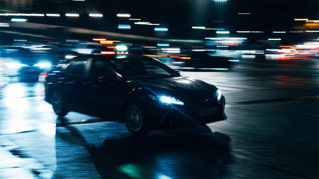 Carro em movimento à noite, com rastros de luz ao redor