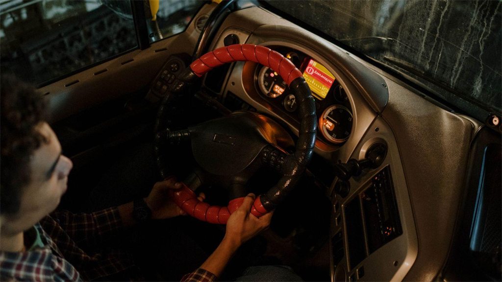 Painel do carro iluminado à noite, com o motorista ao volante