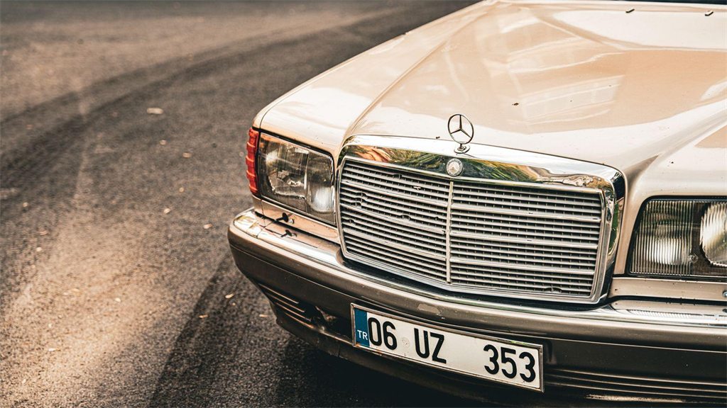 Frente de um Mercedes-Benz antigo em cor clara, com a placa visível