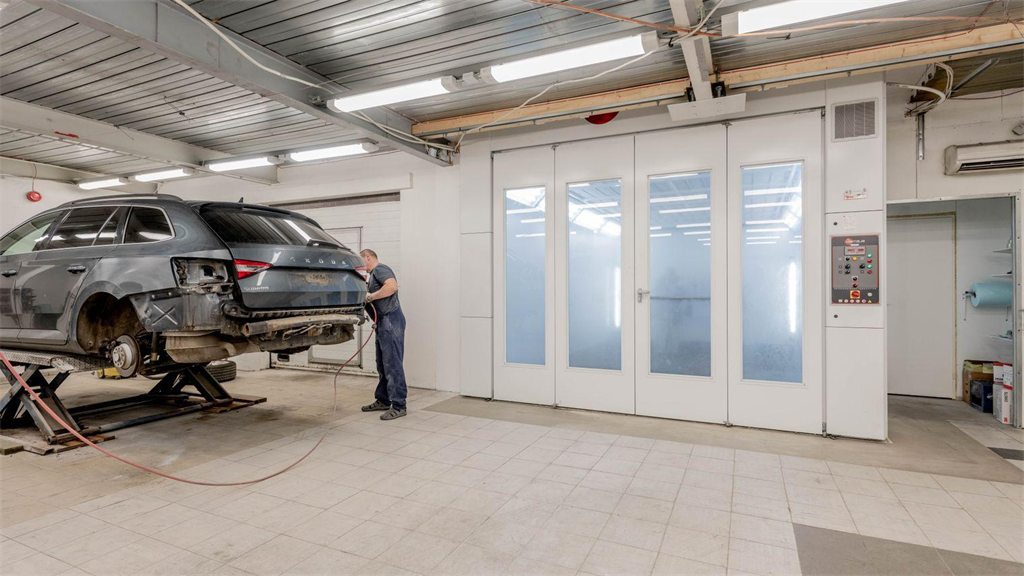 Interior de uma oficina mecânica com um carro no elevador