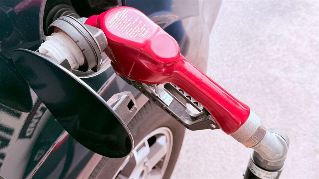 Bico de abastecimento rosa preso à bomba de um posto