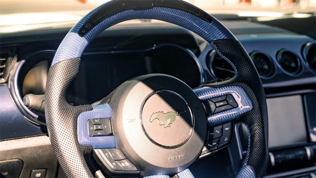 Volante e painel de um carro, vistos do banco do motorista