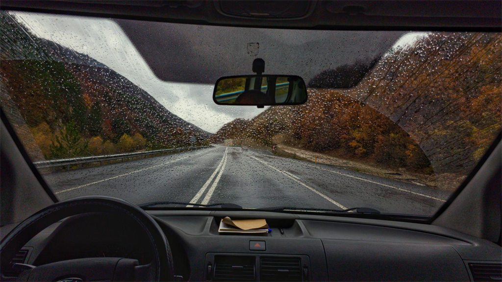 Estrada entre montanhas vista de dentro do carro, pelo para-brisa