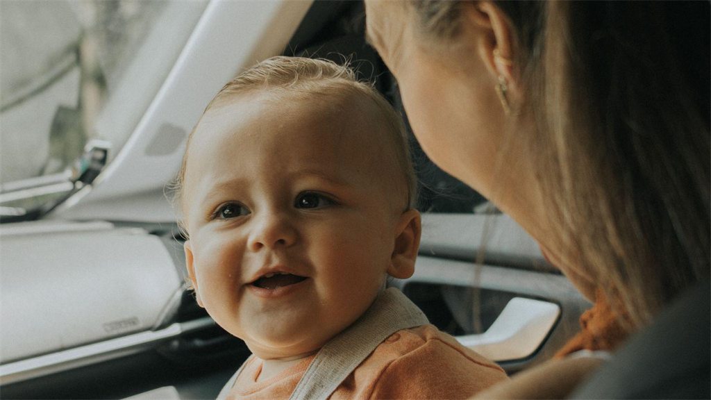 Bebê no colo de uma mulher dentro de um carro
